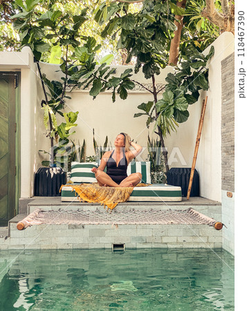 Woman in a black swimsuit relaxing at the pool Woman in a black swimsuit relaxing at the pool 118467390