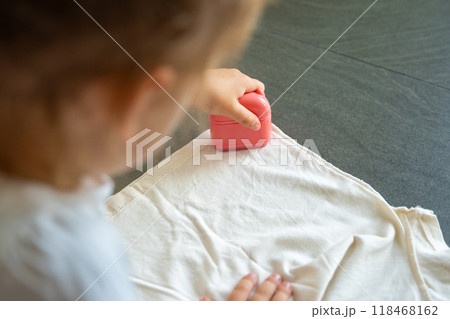 Back view of little girl with a stamp with a name for signing children's things. Identification of personal clothing. 118468162