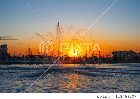 Big fountains illuminated by sunlight at sunset city park 118468287
