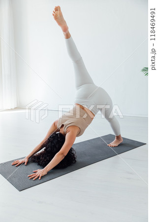 Side view of slim pretty positive young brunette woman doing Utthita parsvakonasana exercise, Side view of slim pretty positive young brunette woman doing Utthita parsvakonasana exercise, 118469491