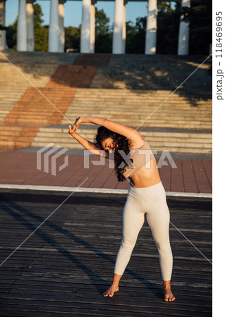 Athletic woman doing gymnastics yoga asana on wooden floor 118469695