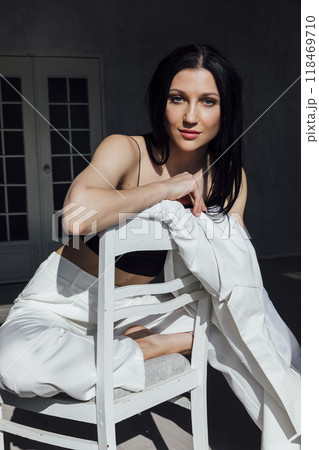 Portrait of a beautiful slender brunette woman in a fashionable white business suit Portrait of a beautiful slender brunette woman in a fashionable white business suit 118469710