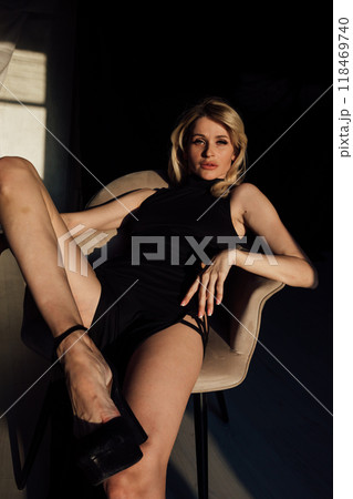 Portrait of a slender blonde woman in a black evening dress 118469740
