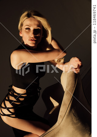 Portrait of a slender blonde woman in a black evening dress Portrait of a slender blonde woman in a black evening dress 118469741