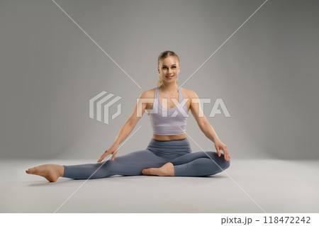 Young woman practicing yoga in a spacious, well-lit studio during morning Young woman practicing yoga in a spacious, well-lit studio during morning 118472242