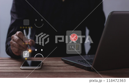 Customer Review, Young man with laptop and smartphone mobile hand holding a pen touching to review Customer Review, Young man with laptop and smartphone mobile hand holding a pen touching to review 118472363