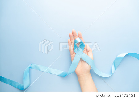 Men's health and Prostate cancer awareness campaign in November. Man hands holding light blue ribbon awareness on sky blue background. Symbol for support men who living with cancer. Copy space. 118472451