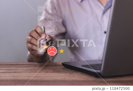 Customer Review, Young man uses laptop hand with pen touching to review and gives 1 star Customer Review, Young man uses laptop hand with pen touching to review and gives 1 star 118472500