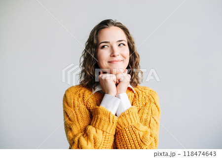 Smiling Woman Dreaming and Thinking. Young woman with a dreamy smile, hands resting on her chin 118474643