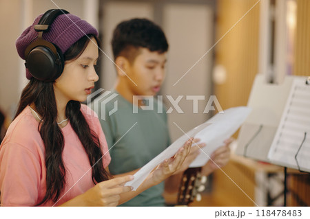 Practicing Singing in Studio with Headphones and Music Sheets 118478483