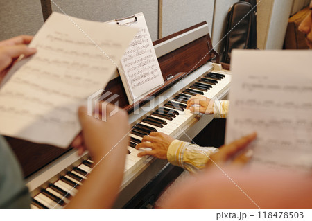 Practicing Music on Piano with Sheet Music Stand 118478503