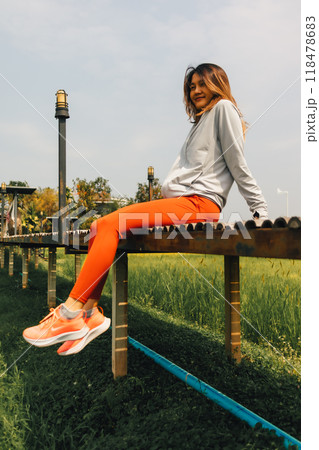 Woman resting at the rice fields after working out in the morning. Woman resting at the rice fields after working out in the morning. 118478683