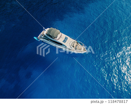 A luxury yacht floating in the middle of deep blue ocean waters A luxury yacht floating in the middle of deep blue ocean waters 118478817