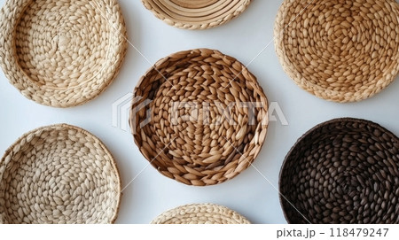 Simple handcrafted woven bowls arranged in a neat pattern on a light surface 118479247