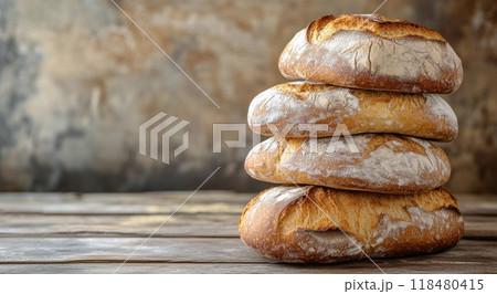 Freshly baked artisan bread loaves stacked neatly on a rustic wooden surface 118480415