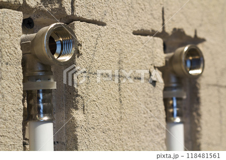 Water pipes made of polypropylene in the wall, plumbing in the house. Installation of sewer pipes in a bathroom of an apartment interior during renovation works. Gray plastic drain pipe for used water 118481561