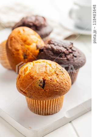 Sweet muffin cakes on cutting board on white table. 118481648