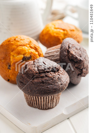 Sweet muffin cakes on cutting board on white table. 118481649