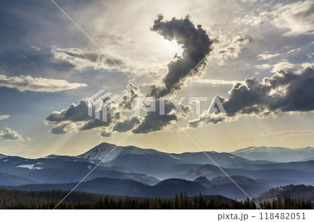 Beautiful fantastic view of blue sky with bright white clouds in mysterious shape of question over magnificent mountain rage with snow covered tops and evergreen pine forest. Beauty of nature concept. Beautiful fantastic view of blue sky with bright white clouds in mysterious shape of question over magnificent mountain rage with snow covered tops and evergreen pine forest. Beauty of nature concept. 118482051