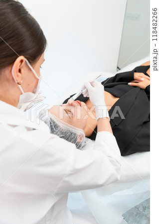 The young female client of cosmetic salon having a cleansing facial mask 118482266