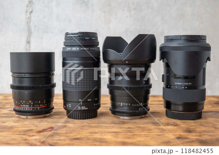 Four different camera lenses standing on a wooden surface Four different camera lenses standing on a wooden surface 118482455