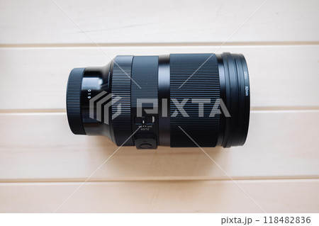 Modern camera lens lying on wooden background Modern camera lens lying on wooden background 118482836