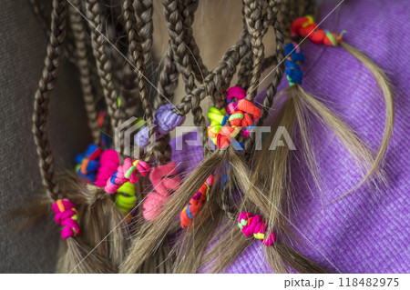 Close up of braid hair of little girl with colorful rubber bands Close up of braid hair of little girl with colorful rubber bands 118482975