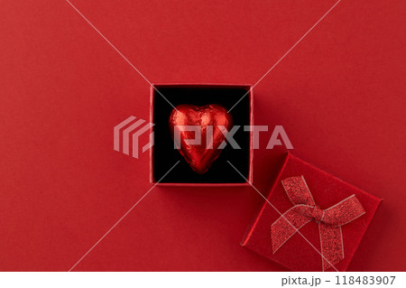 Heart shaped chocolate candy in red gift box on the red background  118483907