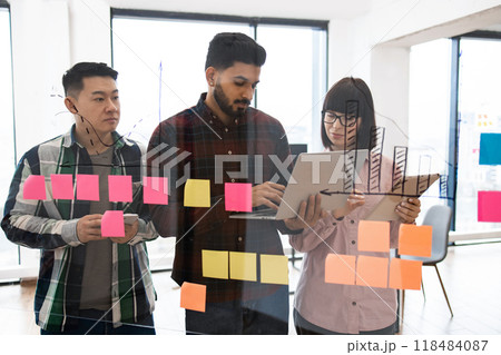 Team collaboration with sticky notes and laptop in modern office 118484087