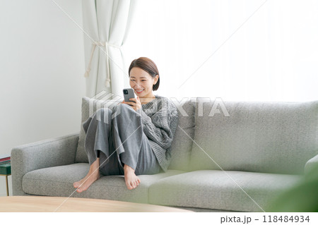 ソファーに座ってスマホを使う女性 118484934
