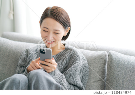 ソファーに座ってスマホを使う女性 118484974