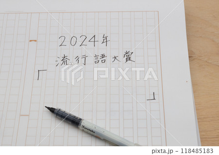 2024年の新語・流行語大賞を予想している　紙に書き出そうとしている 118485183