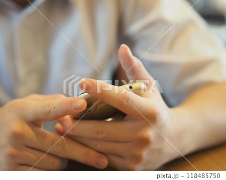 スマホを見る人の手元(正面から) スマホを見る人の手元(正面から) 118485750