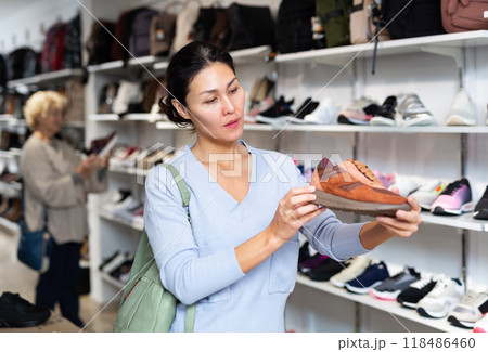 woman selecting running shoes in shoeshop woman selecting running shoes in shoeshop 118486460