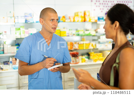 Male doctor writing recipe for client in drugstore Male doctor writing recipe for client in drugstore 118486511