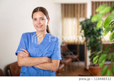 Portrait of positive girl doctor standing in the lobby Portrait of positive girl doctor standing in the lobby 118486512