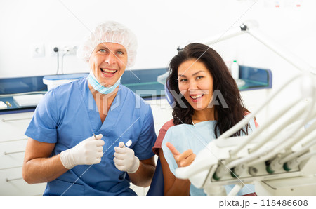 Portrait of a qualified smiling man dentist with a satisfied female patient 118486608
