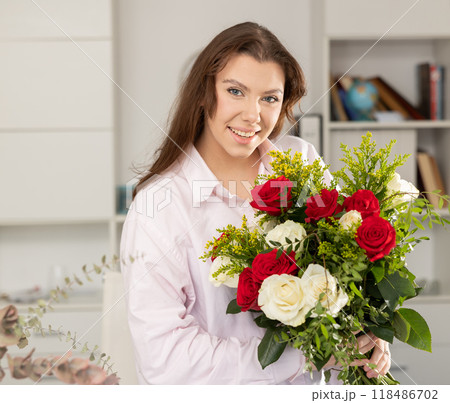 Portrait of successful business woman with a bouquet of flowers in modern office 118486702