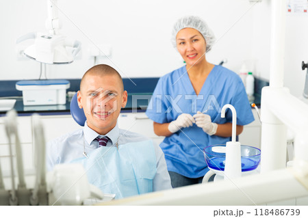 Man is sitting satisfied in chair after treatment in dental clinic 118486739