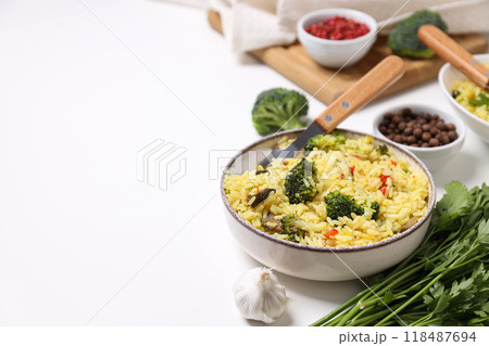 Pilaf in bowls, spices and vegetables on white background, space for text 118487694