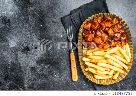 German currywurst with french fry served in a steel plate. Black background. Top view. Copy space German currywurst with french fry served in a steel plate. Black background. Top view. Copy space 118487758