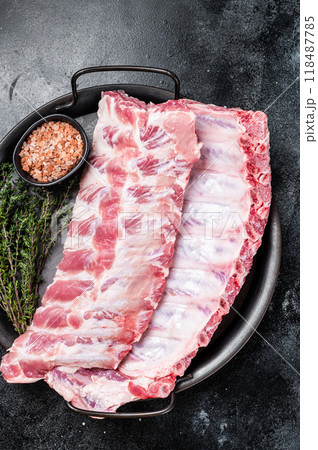 Raw rack of pork spare ribs in steel kitchen tray. Black background. Top view 118487785