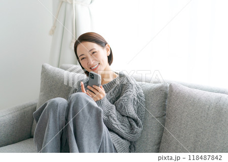 ソファーに座ってスマホを使う女性 118487842