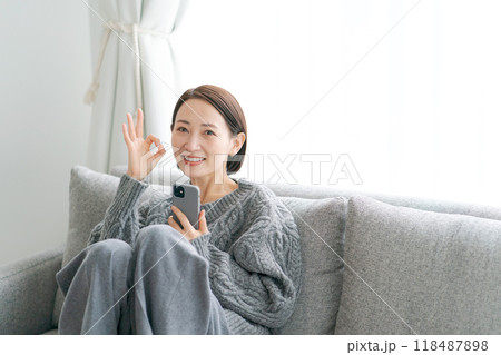 ソファーに座ってスマホを使う女性 118487898
