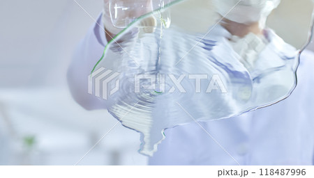 Researcher pour water cascades from a glass beaker, creating ripples in a shallow glass, symbolizing the delicate balance of scientific experimentation in a modern lab. 118487996