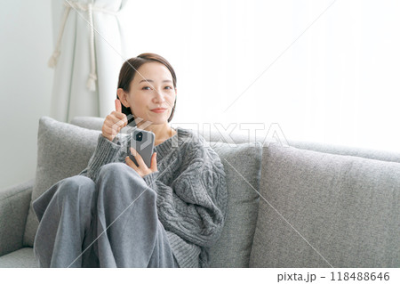 ソファーに座ってスマホを使う女性 118488646