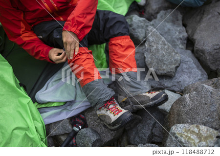 登山靴とスパッツをつける登山者 118488712
