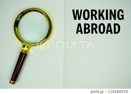 Working Abroad text message written on note page with magnifying glass Working Abroad text message written on note page with magnifying glass 118488939