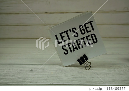 Let's Get Started text message write on sticky note on wooden background 118489355