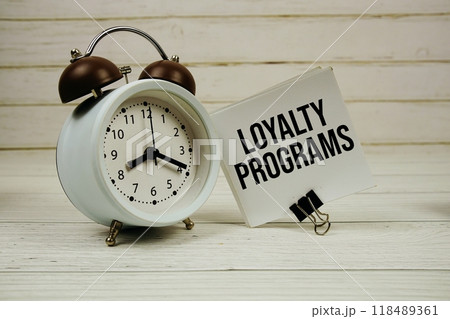 Loyalty Programs text message on sticky note with alarm clcok on wooden background Loyalty Programs text message on sticky note with alarm clcok on wooden background 118489361